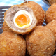 Basket of Scotch eggs with one split open to show cross-section
